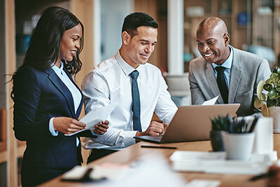 3 people looking at laptop in meeting
