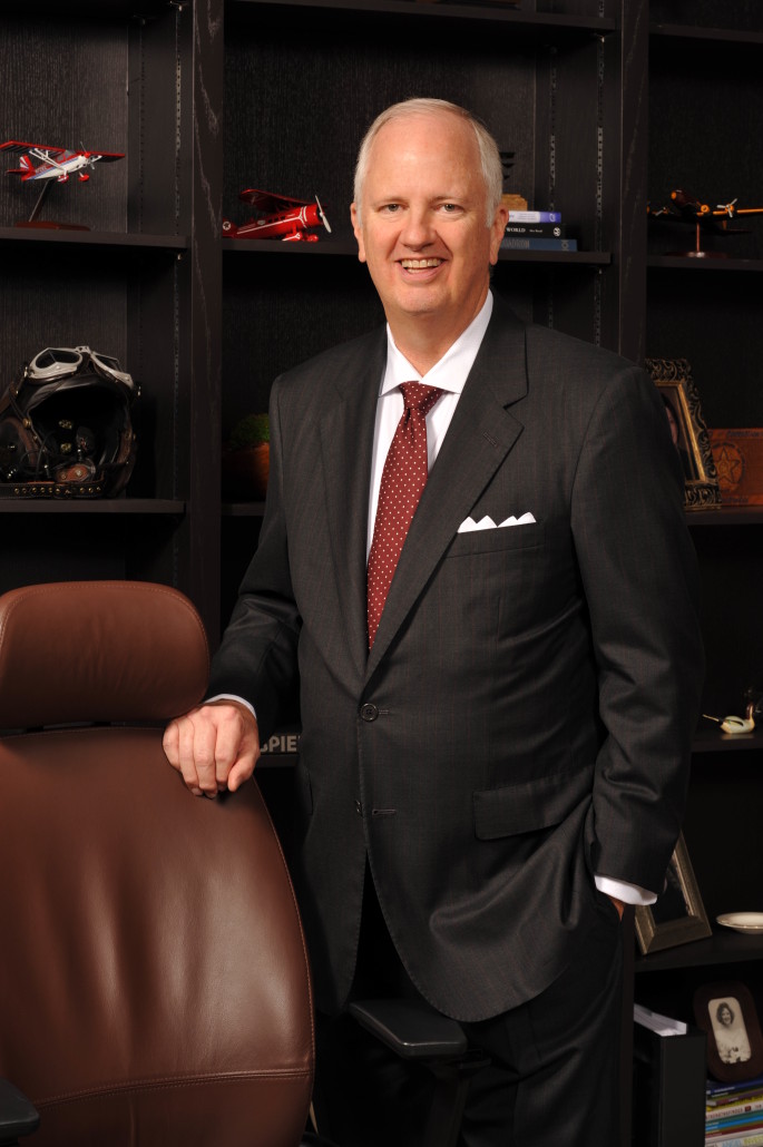 ceo of oaa tony caldwell standing in office at chair