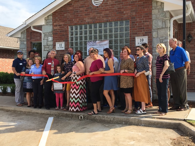 OAA team standing outside about to cut a red ribbon