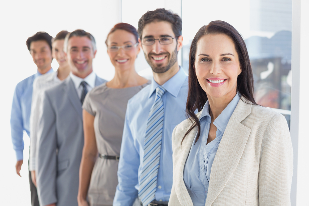 business men and women standing in a line smiling